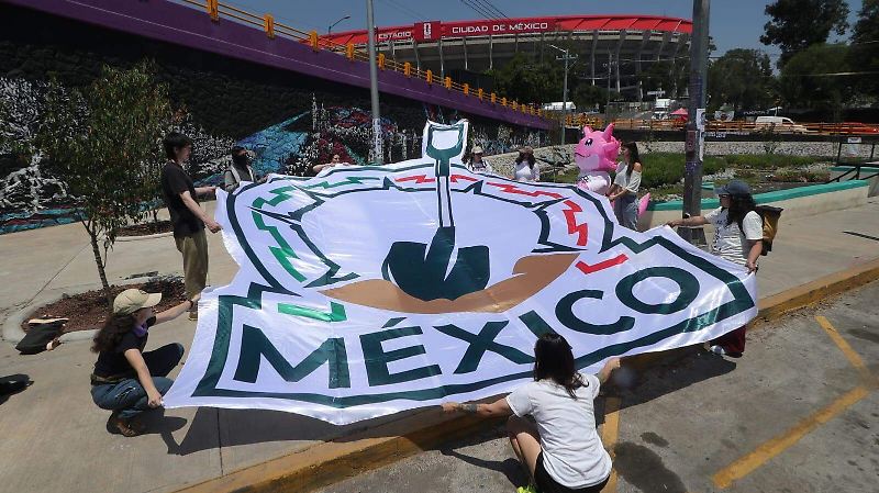 Con un ajolote y una pala “mundialista” familias pegan fichas de búsqueda cerca del Estadio Azteca